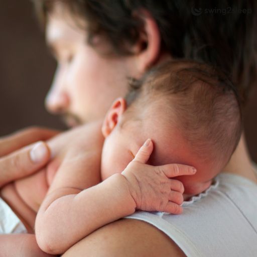 Vater bringt Neugeborenes zum Schlafen